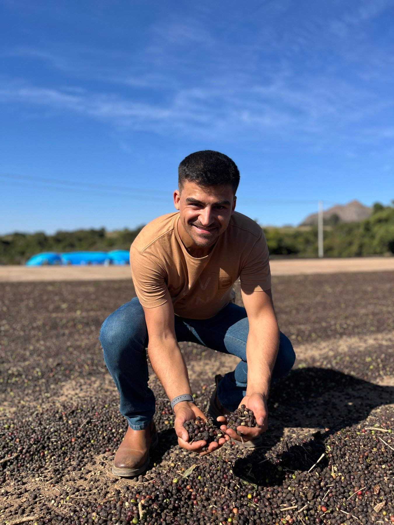 Vinicius no terreiro da Fazenda Goiabas com café nas mãos